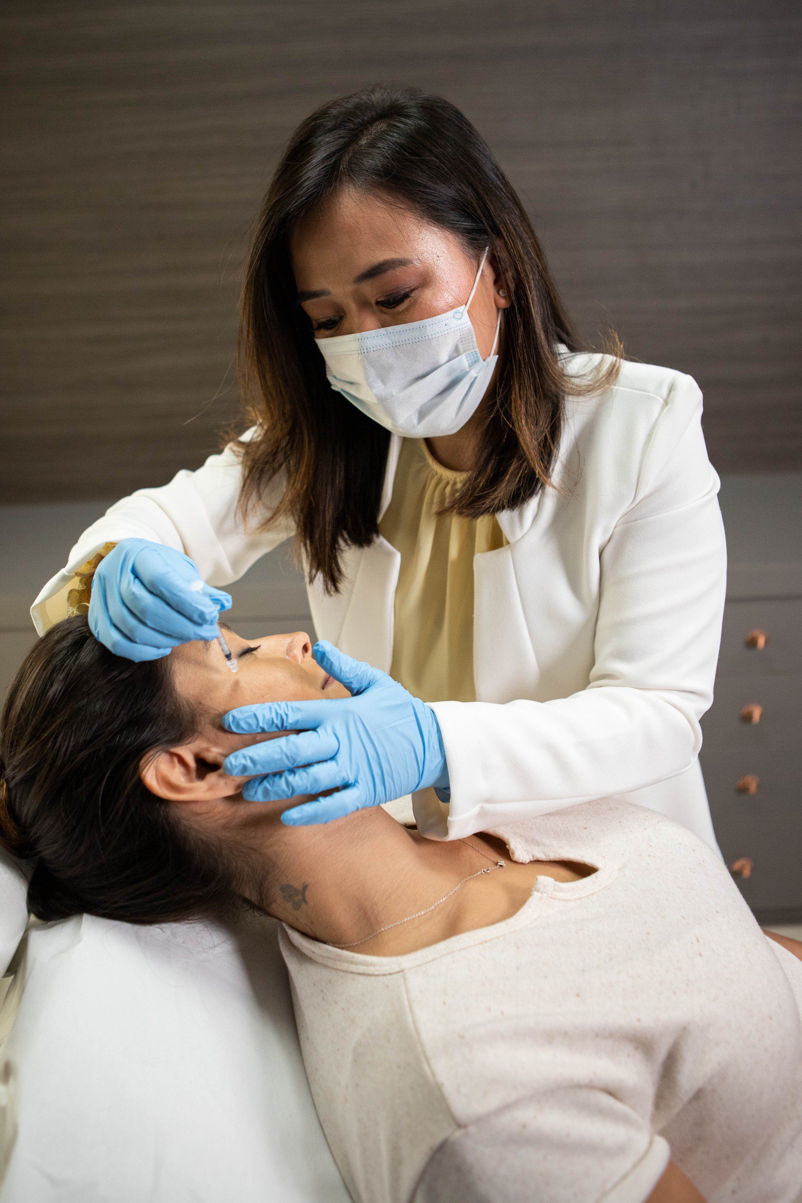 Dra. Juliana Toma realizando procedimento facial em contexto dermatológico