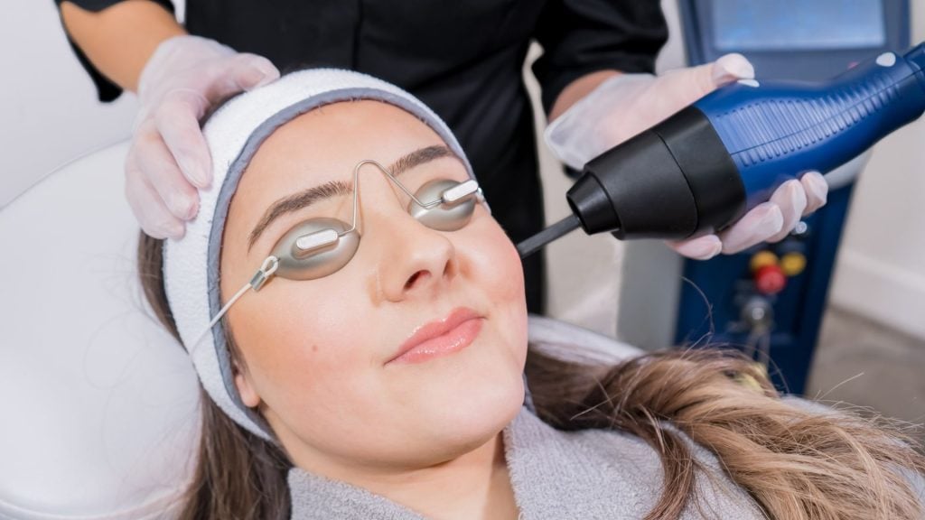 Procedimento facial com equipamento e proteção sobre os olhos.