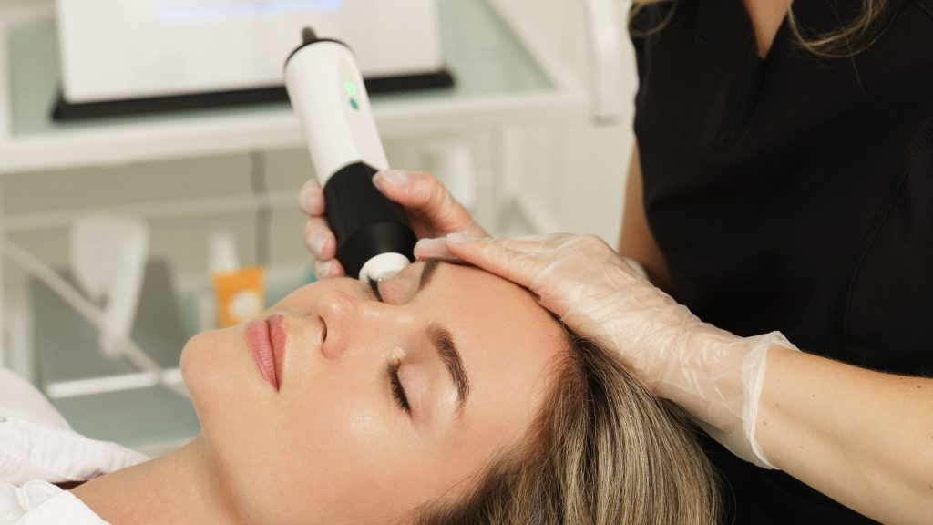 Aplicação de um dispositivo sobre a testa durante um procedimento facial.