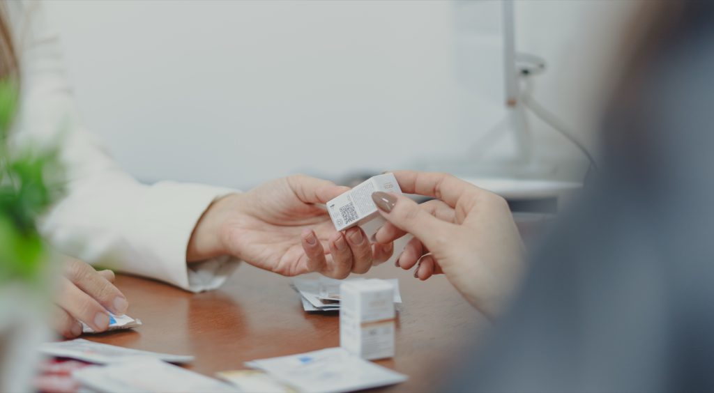 Mãos com uma amostra de dermocosmético durante a consulta