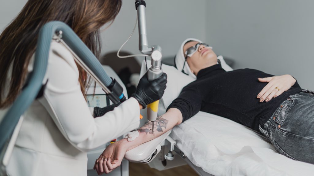 Dra. Juliana Toma dispara laser sobre tatuagem no antebraço da paciente