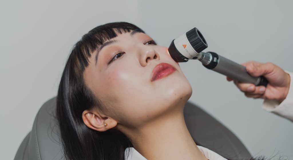 Exame da pele da face com dermatoscópio.