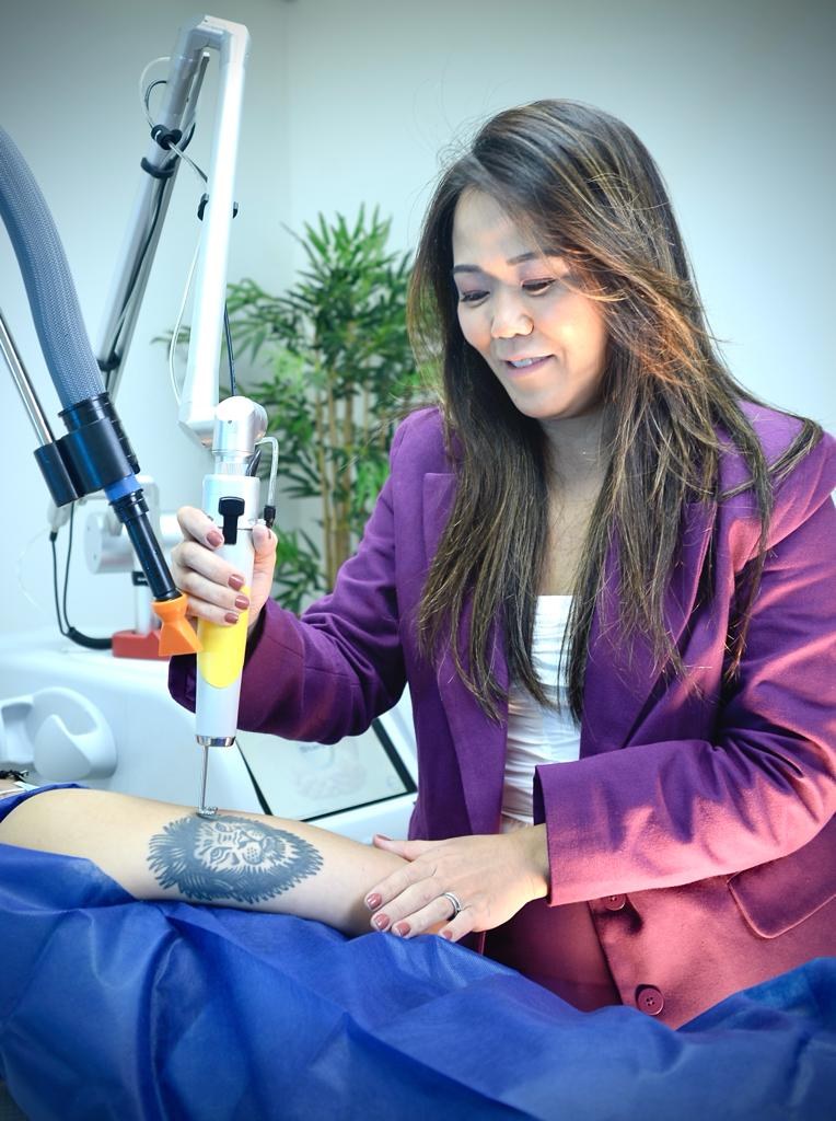 Dra. Juliana Toma aplicando o laser em uma tatuagem, em ensaio para a IstoÉ